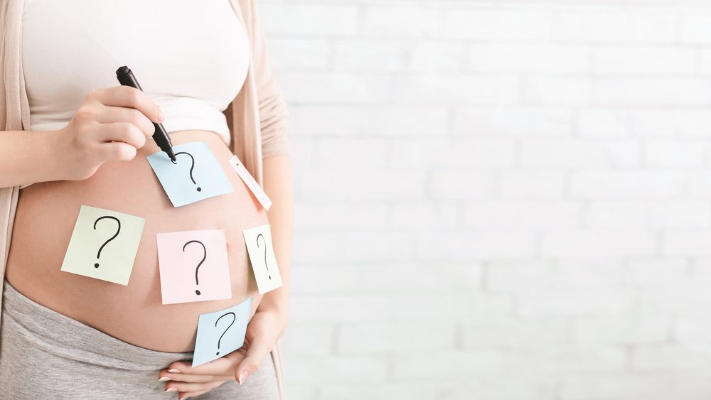 Pregnant woman with paper stickers on tummy